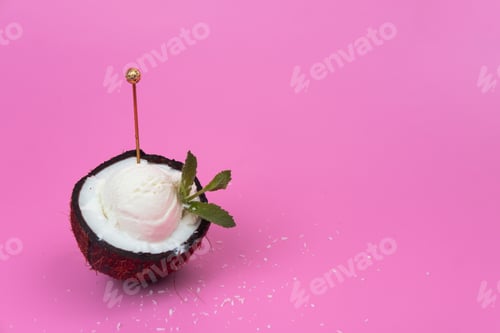 Preview: Vanilla ice cream balls in a fresh coconut half decorated with mint leaves with a spoon on a pink