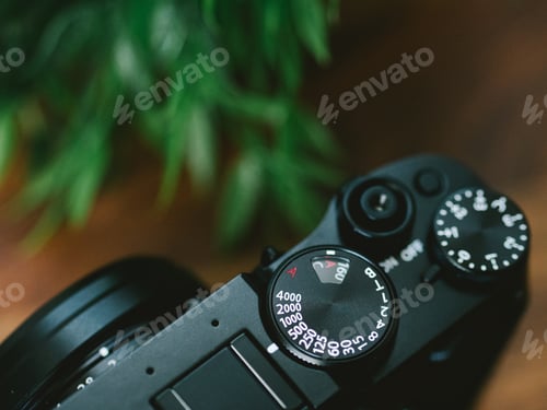 Preview: High angle closeup of the mode dial of a camera on the table under the lights