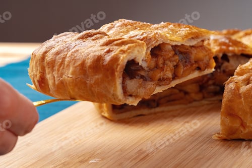 Preview: Apple pie on a wooden board cut into pieces