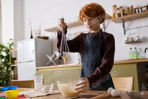 Preview: Joyful moments of a little boy creating delicious treats in a cozy kitchen space