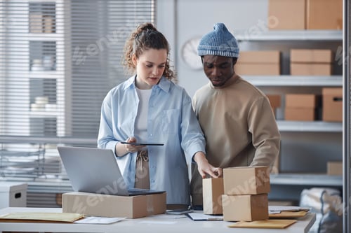Preview: Young female manager explaining colleague where to look for address of receiver