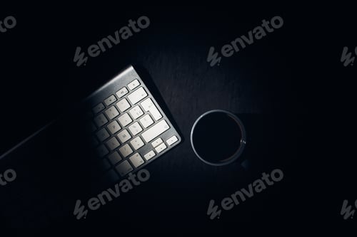 Preview: Top view of a keyboard and a cup of hot coffee on a table - work from home concept