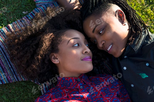 Preview: Lesbian couple lying together in park, face to face