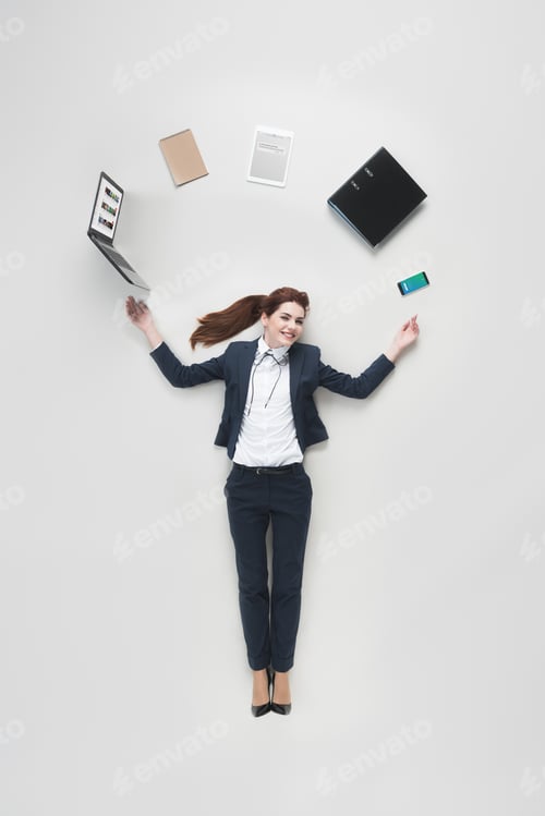 Preview: overhead view of businesswoman with various office supplies using laptop isolated on grey
