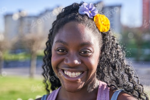 Preview: Portrait of a young African American girl smiling with flowers in her hair.