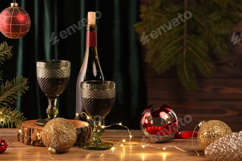 Preview: Red wine and beautiful Christmas decor on wooden table. Space for text