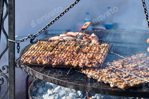 Preview: Cooking chicken barbecue on BBQ grill basket with wooden handle, thick delicious smoke