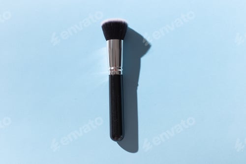 Preview: Make up brush on blue background, top view