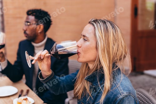 Preview: young Caucasian woman drinking red wine from a glass
