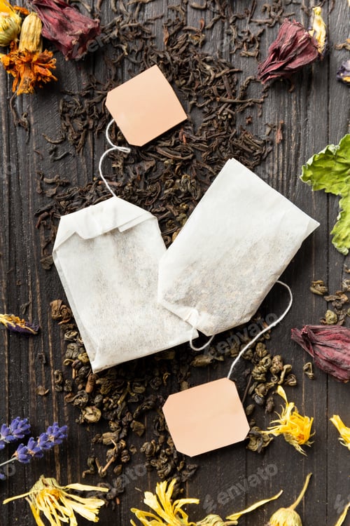 Preview: Dry green and black tea, tea bags, flower tea on a dark background top view close-up.