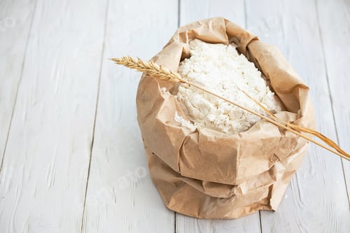 Preview: Wheat Flour in Paper Pack with Ears of Wheats on White Wooden Table.