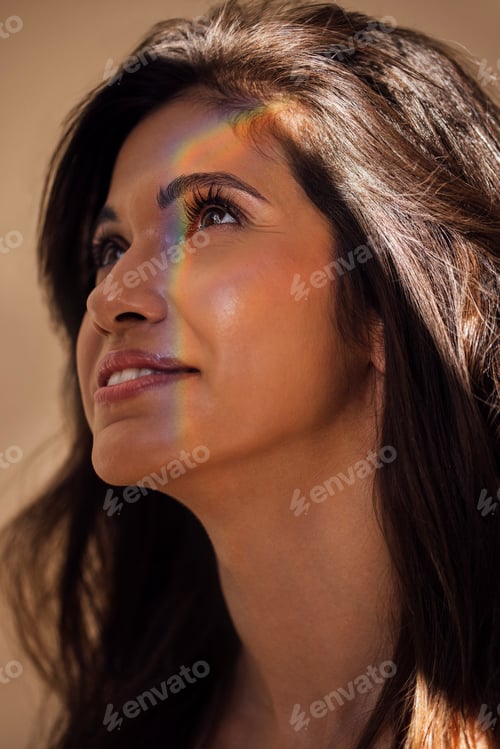 Preview: Woman with long dark hair gazes upward, illuminated by soft natural light