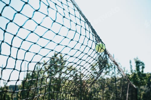 Preview: Time stop image of a tennis ball crashing against the court net with copy space, sport concept