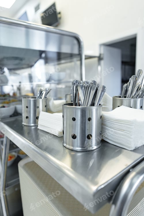 Preview: Stainless Steel Utensils Organized in Containers on a Service Cart in a Commercial Kitchen