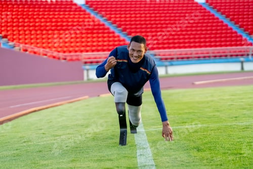 Preview: Asian para-athletes with prosthetic blades sprint on a running track at stadium.