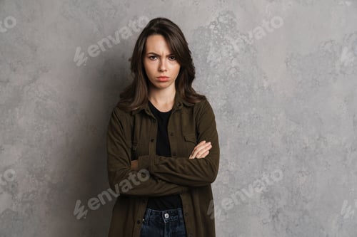 Preview: Displeased beautiful brunette girl posing with arms crossed i