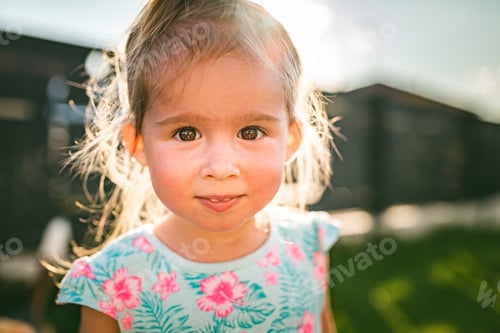 Preview: Beautiful baby girl portrait in sunny, green yard in summer