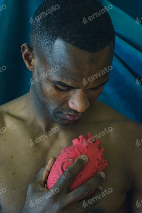 Preview: fit young african american black muscular man holding a heart shaped object depict emotion and love