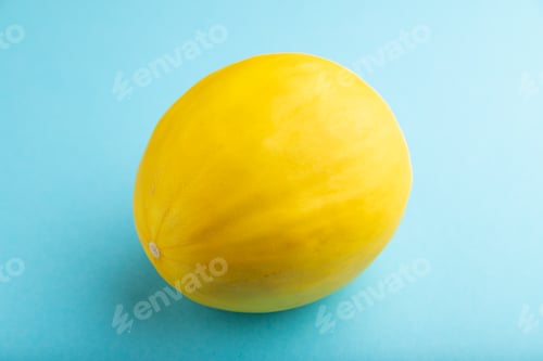 Preview: Ripe yellow melon on blue pastel background. Side view, close up.