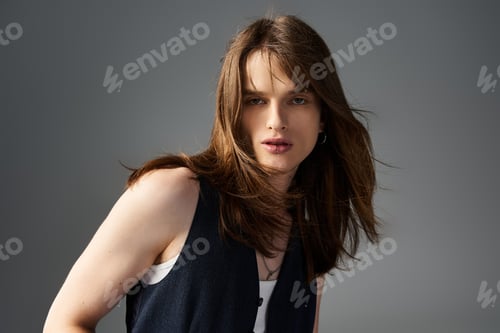 Preview: A young stylish man showcasing fashionable attire with an expressive gaze in a minimalist setting