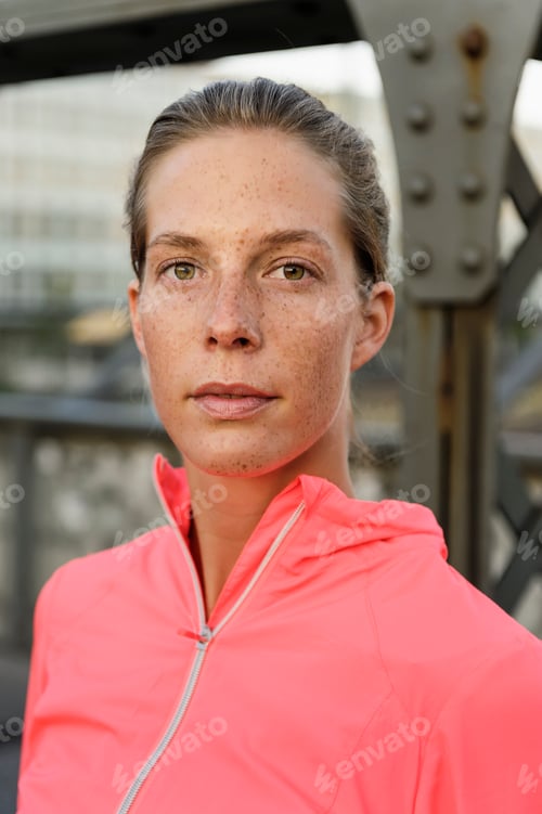 Preview: Portrait of confident young female runner on bridge