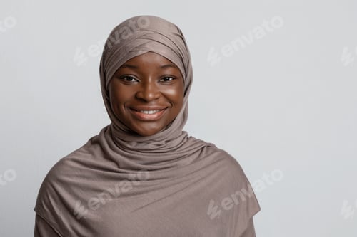 Preview: Portrait of beautiful african muslim woman in hijab over light studio background