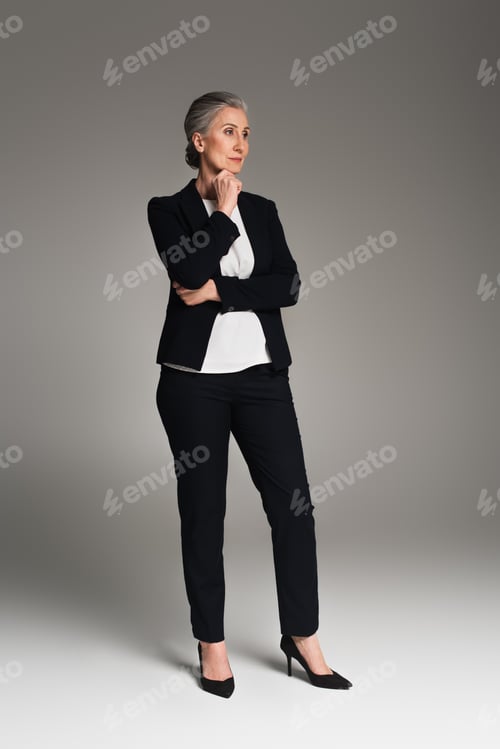 Preview: Full length of mature manager on grey background