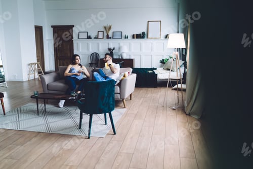Preview: Young multiethnic couple lounging on sofa