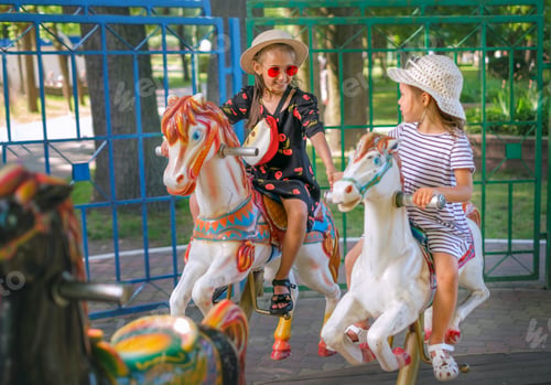 Preview: The sisters ride in a circle on carousel sitting on colored horses