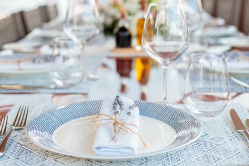 Preview: Holiday table setting with white and blue plates, folded napkins and wine glasses