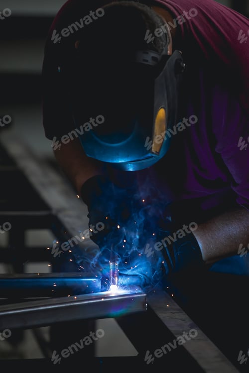 Preview: Industry worker welding iron pieces at work