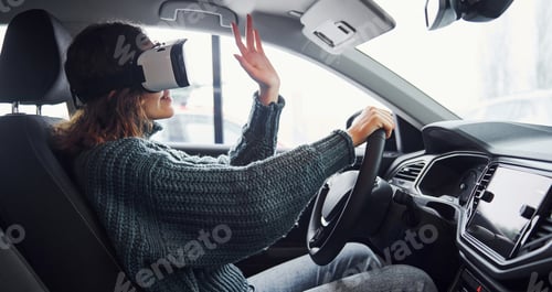 Preview: Side view of woman in virtual reality glasses that sitting inside of modern car