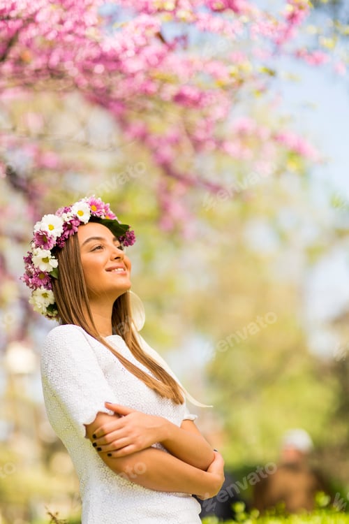 Preview: Young woman with flowers in her hair on sunny spring day