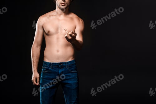 Preview: partial view of shirtless man showing middle finger to camera isolated on black