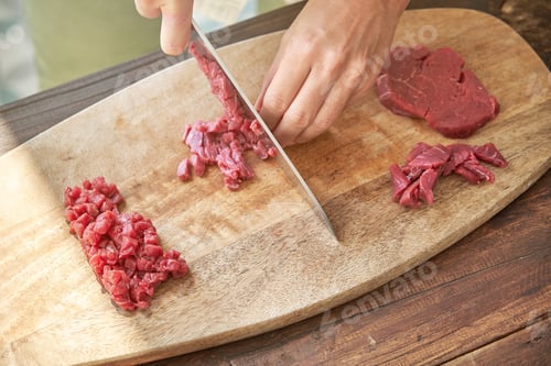 Preview: Crop cook chopping meat on wooden board