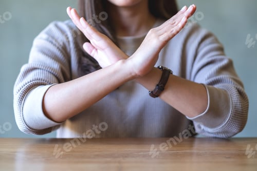 Preview: Closeup image of a woman making crossed arms sign