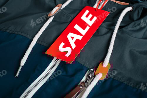 Preview: Advertising text Sale on a red tag attached to clothes, close-up. Black Friday, annual big