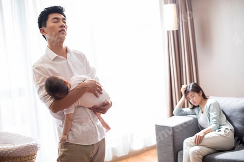 Preview: Tired father holding his sleeping baby