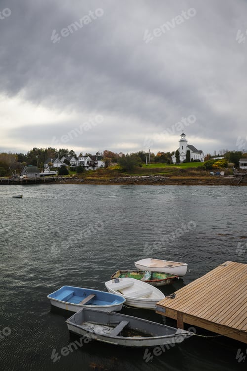 Preview: Row of boats on a dock in a harbor along the Maine Coast with a church in the background