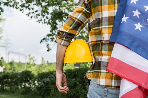 Preview: back view of cropped foreman with usa flag and hardhat outdoors, labor day concept