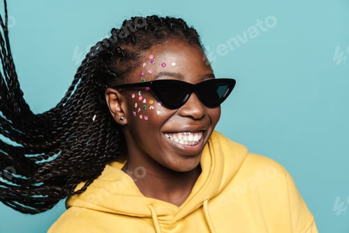 Preview: Young black woman with stickers on her face smiling at camera