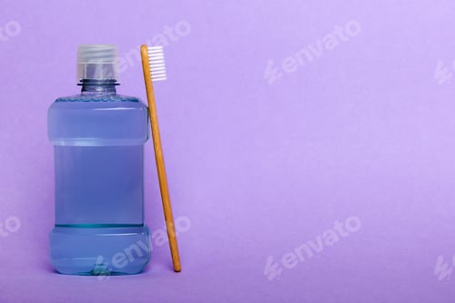 Preview: Mouthwash and other oral hygiene products on colored table top view with copy space.