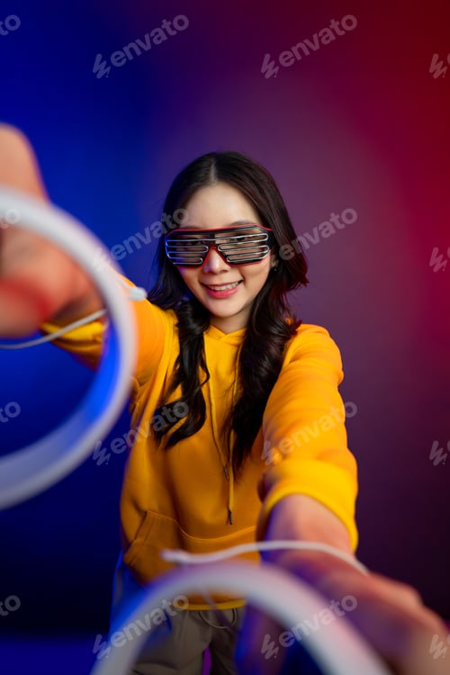 Preview: Portrait of Asian young woman gamer playing games in neon background.