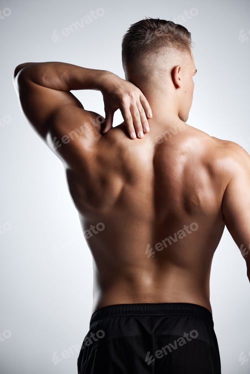 Preview: Studio shot of a muscular young man posing against a grey background