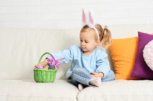 Preview: Cute Child with Easter Basket on Couch