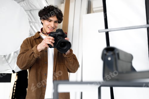 Preview: Content photoshoot. Young man photographer working with modern equipment and making photos of bags
