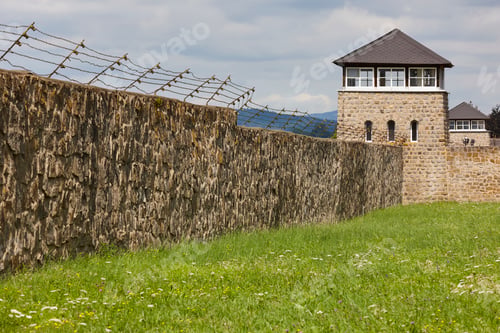 Preview: Mauthausen memorial camp. Stone wall with fence and watchtower. Austria