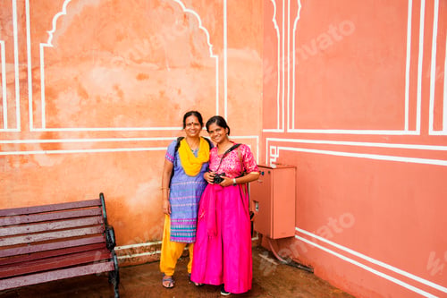 Preview: Indian women in traditional clothes on red wall background