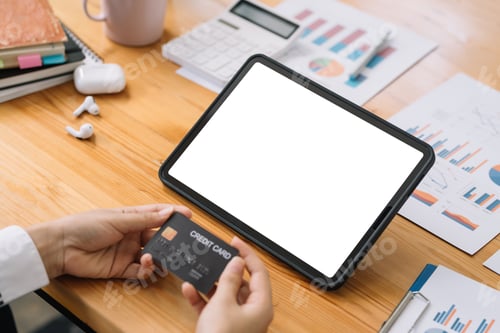 Preview: Close-up image of woman hands using tablet blank white screen and holding credit card.
