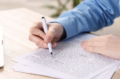 Preview: Woman underlining important information with marker at wooden desk indoors, closeup